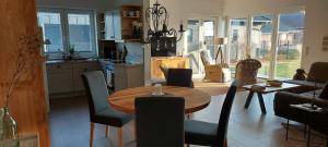 a kitchen and living room with a table and chairs at Haus Admaris am Wangermeer in Wangerland