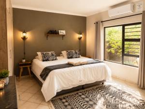 a bedroom with a large bed and a window at Maningwe in Marloth Park +33 photos