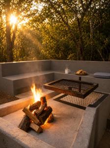 a fire pit with a table and a grill at Maningwe in Marloth Park