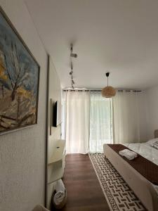 a bedroom with a bed and a large window at Vatra Dumeniului in Vorniceni