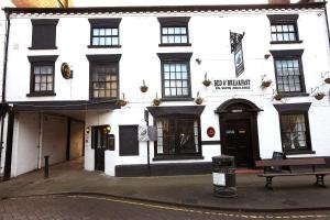a white building with a bench in front of it at The Black Swan Inn in Leominster