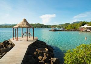 a wooden pier with a gazebo on the water at Appartement ALYA in Les Trois-Îlets