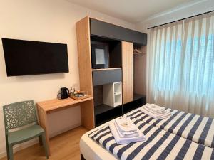 a hotel room with a bed and a desk and a television at Bastian B&B in Sarmede