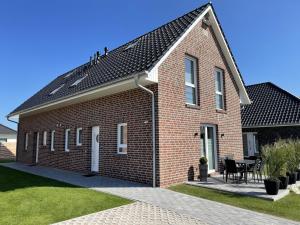 a red brick house with a black roof at Wangerstrand in Wangerland
