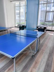 two ping pong tables in a room with windows at Bahrain Bay Retreat Studio in Manama