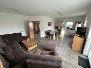 a living room with a couch and a table at Am Wangermeer 38 in Wangerland +12 photos