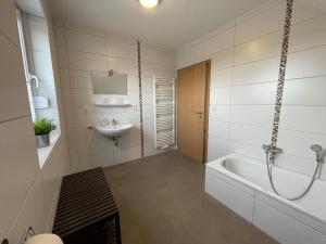 a bathroom with a bath tub and a sink at Am Wangermeer 38 in Wangerland