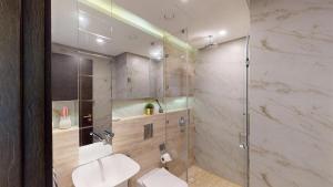 a bathroom with a shower with a sink and a toilet at Bahrain Bay Retreat Studio in Manama