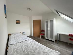 a white bedroom with a bed and a desk at Am Wangermeer 38 in Wangerland