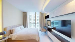 a bedroom with a large bed and a tv at Bahrain Bay Retreat Studio in Manama