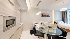 a living room with a glass table and a bed at Bahrain Bay Retreat Studio in Manama