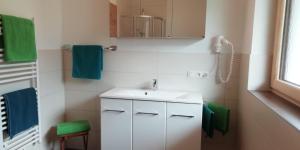 a bathroom with a white sink and green towels at Ferienwohnung Thanner in Stumm +42 photos