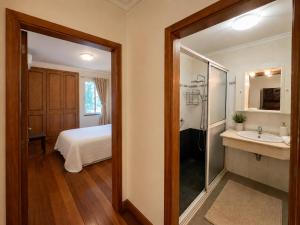 a bathroom with a bed and a shower and a sink at Cantinho de Santa Teresa in Canhas
