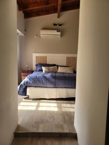 a bedroom with a bed with a blue comforter at BAHIA BLANCA-BARRIO PARQUE in Bahía Blanca +20 photos