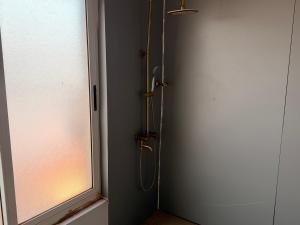 a shower in a bathroom with a door and a window at Fitini appart in Bamako