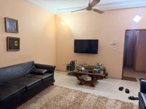 a living room with a black couch and a tv at Fitini appart in Bamako