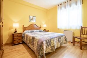 a bedroom with a bed and two lamps and a window at Pension Monteverde in Cangas de Onís