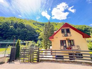 a small house with a gate and a fence at Casa Trei Brazi Bratca in Bratca