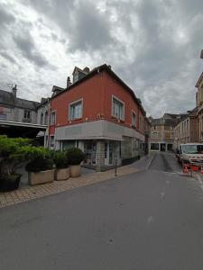 a red building on the side of a street at Au cœur de Givet in Givet