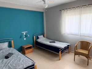 a room with two beds and a chair and a window at Iberfishing Apartmanok in Caspe