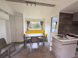 a kitchen and dining room with a table and chairs at Bungalow Camping 4 étoiles in Messanges