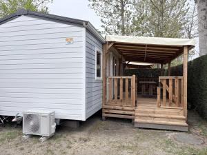 a tiny house with a porch and a patio at Bungalow Camping 4 étoiles in Messanges