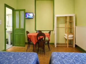 a room with a table with chairs and a television at Hôtel du Nord in Contrexéville