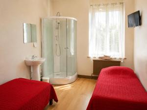 a bathroom with a shower and a sink and two beds at Hôtel du Nord in Contrexéville