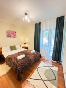 a bedroom with a bed and a large window at Casa Trei Brazi Bratca in Bratca