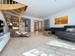 a living room with a couch and a staircase at Haus Strandgut in Hooksiel in Wangerland