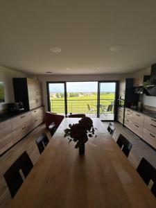 a dining room table with a vase of flowers on it at Vignes au Balcon in Villers-Marmery