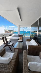 a room with several beds and chairs and the ocean at Casa do Mar Oeiras in Oeiras