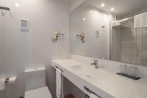 a white bathroom with a sink and a toilet at Hotel Silken Don Pepe y Don Pepe Ría in Ribadesella +92 photos