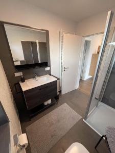 a bathroom with a sink and a mirror at Steuerbord Nock mit Hund in Wangerland +10 photos