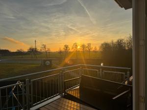 a view of the sunset from the porch of a house at Steuerbord Nock mit Hund in Wangerland