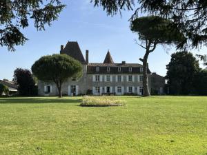 an old house with trees in a field at Maison Mélusine in Londigny
