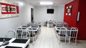 a dining room with tables and chairs and a red wall at Hotel Vila Planalto in Brasília