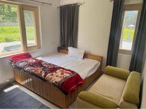 a small bedroom with a bed and a chair at Samoon Guest House in Karnāl