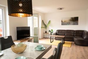 a living room with a couch and a table at Haus Wanger Meerblick in Wangerland