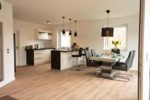 a kitchen and dining room with a table and chairs at Haus Wanger Meerblick in Wangerland
