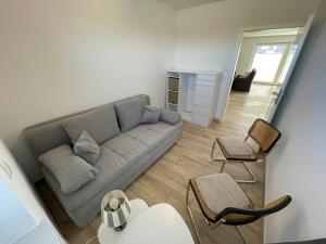 a living room with a couch and a chair at Wangerkajüte in Wangerland