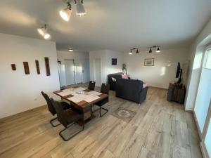 a living room with a table and a couch at Wangerkajüte in Wangerland +5 photos