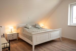 a bedroom with a white bed with two pillows on it at Haus Wanger Meerblick in Wangerland
