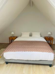 a bedroom with a large bed with two night stands at GITES EN BAIE DE SOMME - Maison Nolette in Noyelles-sur-Mer