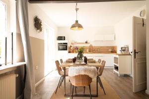 a kitchen and dining room with a table and chairs at Haus mit Herz in Wangerland