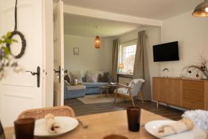 a living room with a couch and a table at Haus mit Herz in Wangerland