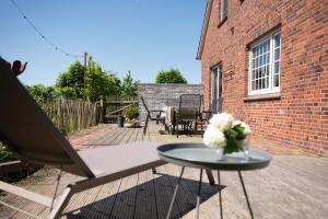 a table with a vase of flowers on a patio at Haus mit Herz in Wangerland