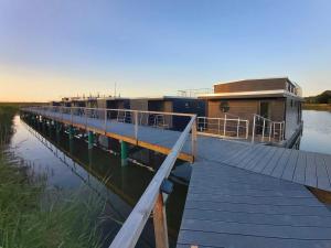 a house on a dock on a body of water at Hausboot MeerZeit in Wangerland