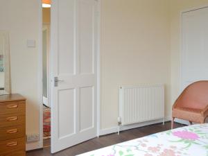 a bedroom with a white closet door and a bed at Beuchan Bungalow in Closeburn +5 photos