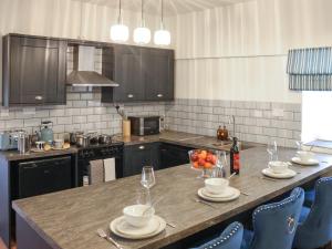 a kitchen with a table with a bowl of fruit on it at Stable End in Llandysul